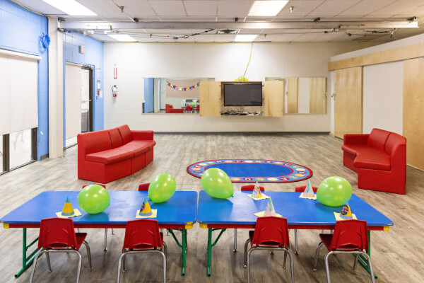 Black tusk room with couches, tables and chairs set up for a birthday party.