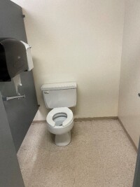 Municipal hall accessible washroom stall with grab bar.